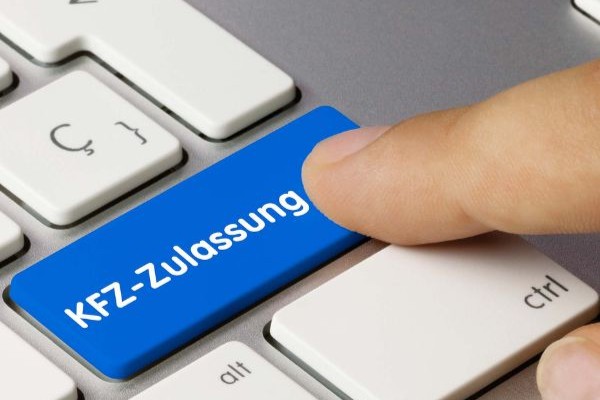 Nahaufnahme eines Fingers, der auf eine Tastaturtaste mit der Beschriftung "KFZ-Zulassung" drückt | Auto online anmelden